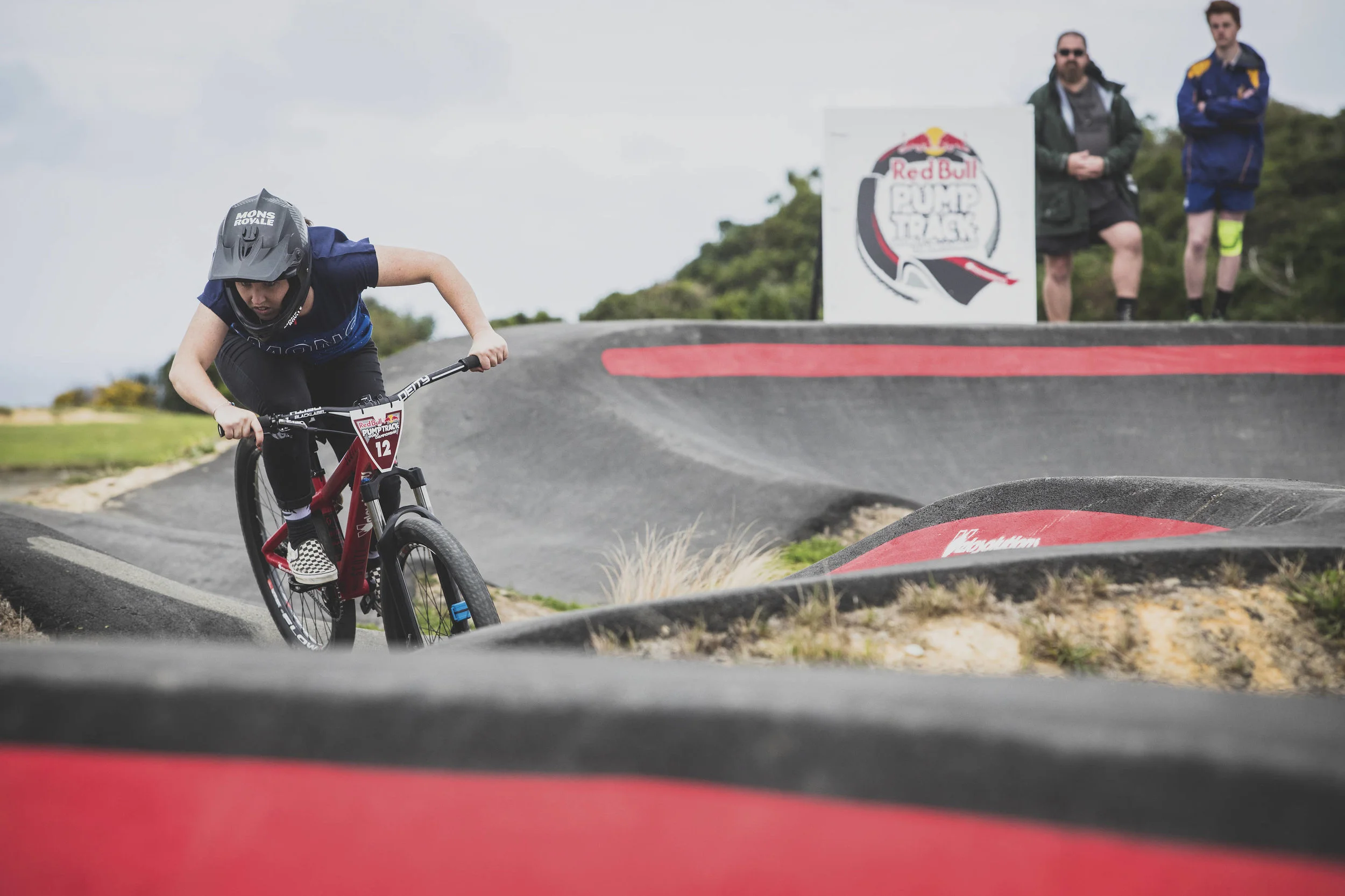 A sealed pump track with red berms, built for a community bike park.